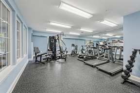 A spacious gym with a variety of equipment including treadmills, weights, and exercise machines.